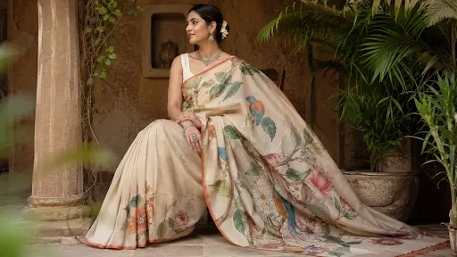 Indian woman wearing an elegant beige floral printed saree in a traditional heritage setting