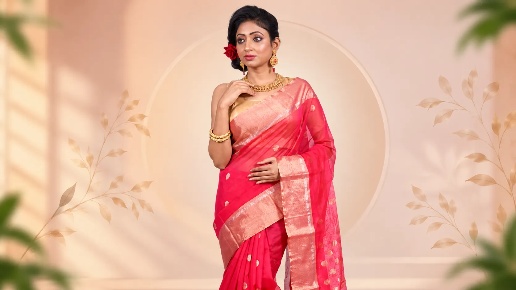Indian woman wearing a vibrant pink silk saree with a golden zari border, styled with traditional gold jewellery for a festive ethnic look.