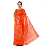 Indian woman wearing a vibrant orange-red silk saree featuring delicate golden woven motifs, a decorative border and a flowing pallu.