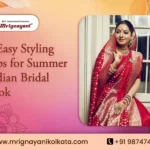 Indian bride wearing a traditional red Banarasi saree with intricate gold zari work and bridal jewellery, featured in Mrignayani Kolkata's guide to 6 easy summer bridal styling tips.